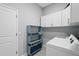 Functional laundry room with a washer, dryer, storage cabinets, and shelving at 3229 Medici Blvd, New Smyrna Beach, FL 32168
