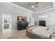 Well-lit primary bedroom featuring a modern dresser, tray ceilings, and an adjacent ensuite bathroom at 3229 Medici Blvd, New Smyrna Beach, FL 32168