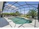 Screened pool with lounge chairs, a waterfall feature, a lake view, and tropical landscaping at 3229 Medici Blvd, New Smyrna Beach, FL 32168