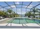 Screened pool with lake view, a waterfall feature, and beautiful tropical landscaping at 3229 Medici Blvd, New Smyrna Beach, FL 32168