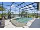 Beautiful screened pool with lounge chairs, a lake view, a waterfall feature, and tropical landscaping at 3229 Medici Blvd, New Smyrna Beach, FL 32168