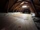 View of the unfinished attic with wooden beams, insulation, and plywood flooring at 3322 Modena Way, New Smyrna Beach, FL 32168