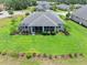 A view from above showing a lush backyard with a screened lanai, beautiful landscaping, and meticulous lawn care at 3322 Modena Way, New Smyrna Beach, FL 32168