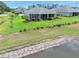 Picture-perfect backyard featuring lush green lawn, meticulous landscaping, a screened lanai, and tranquil lake views at 3322 Modena Way, New Smyrna Beach, FL 32168