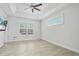 Bright bedroom featuring neutral walls, tile floors, tray ceiling, and large windows with plantation shutters at 3322 Modena Way, New Smyrna Beach, FL 32168