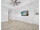 Light and airy bedroom with tile floors, tray ceiling with fan, and television mounted on the wall at 3322 Modena Way, New Smyrna Beach, FL 32168
