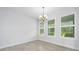 Dining area with white walls, tile floors, three windows, and a chandelier at 3322 Modena Way, New Smyrna Beach, FL 32168