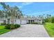 The front exterior welcomes you with a paver driveway, immaculate landscaping, and a three-car garage in a stylish, modern design at 3322 Modena Way, New Smyrna Beach, FL 32168