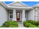 Inviting front porch with stone pillars and a red front door, creating a welcoming entrance at 3322 Modena Way, New Smyrna Beach, FL 32168