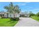 Charming home featuring a beautiful palm tree and a paved driveway leading to a two-car garage at 3322 Modena Way, New Smyrna Beach, FL 32168