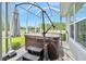 Outdoor covered hot tub has seating, an umbrella, and a view of a pond at 3322 Modena Way, New Smyrna Beach, FL 32168