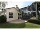 View of the backyard with a screen enclosed patio and a brick tiled area at 340 Hampton Hills Ct, Debary, FL 32713
