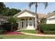 Inviting front entrance with a decorative glass door, manicured landscaping, and beautiful flowerbeds at 340 Hampton Hills Ct, Debary, FL 32713