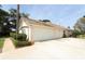 Spacious three-car garage with a wide driveway, complemented by lush greenery and a tile roof at 340 Hampton Hills Ct, Debary, FL 32713