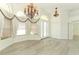 Spacious living room with light wood flooring, ornate chandeliers, and lots of natural light through large windows at 340 Hampton Hills Ct, Debary, FL 32713