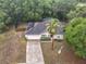 Overhead view of a house with a pool enclosure, a fenced backyard, and lush surrounding trees at 400 Landress Ln, Deland, FL 32724