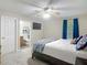 This bedroom features an ensuite bathroom, ceiling fan and a window with blue drapes at 400 Landress Ln, Deland, FL 32724