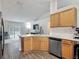 Open kitchen featuring quartz countertops, wood cabinets, stainless steel appliances, and a view of the living area and pool at 400 Landress Ln, Deland, FL 32724