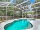 Backyard view of a beautiful, screened-in pool with mature trees and a storage shed in the background at 400 Landress Ln, Deland, FL 32724