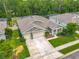 Overhead view of a well-maintained home with manicured lawn, complemented by a two-car garage and charming landscaping at 409 Nowell Loop, Deland, FL 32724