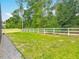 Expansive backyard with green lawn, a white fence, and mature trees, perfect for outdoor activities at 409 Nowell Loop, Deland, FL 32724