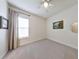 Bright bedroom with ceiling fan, soft carpet, and a window for natural light at 409 Nowell Loop, Deland, FL 32724
