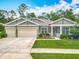 Beautiful single-story home with manicured lawn, complemented by a two-car garage and inviting front porch at 409 Nowell Loop, Deland, FL 32724