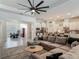 Spacious living room offers an oversized sectional sofa, ceiling fan, and access to the kitchen and dining areas at 409 Nowell Loop, Deland, FL 32724