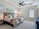Spacious main bedroom boasts neutral tones, tray ceiling, ceiling fan, and plush carpeting at 409 Nowell Loop, Deland, FL 32724
