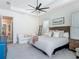 Bright main bedroom features a tray ceiling, ceiling fan, couch and an ensuite bathroom and kitchen access at 409 Nowell Loop, Deland, FL 32724
