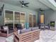 Covered patio with comfortable seating, ceiling fans, and views of the fenced backyard at 409 Nowell Loop, Deland, FL 32724