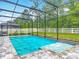 Beautiful in-ground pool with a jacuzzi and screened enclosure surrounded by well-maintained landscaping at 409 Nowell Loop, Deland, FL 32724