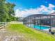 A beautiful fenced backyard features a screened pool and lounge seating at 409 Nowell Loop, Deland, FL 32724