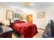 Bedroom with a red bedspread, dark wooden furniture, and a window with natural light at 409 S Sparkman Ave, Orange City, FL 32763