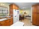 Kitchen with a white refrigerator, wooden cabinets, tile floors, and an adjacent dining area at 409 S Sparkman Ave, Orange City, FL 32763