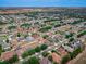 A sweeping aerial shot showcasing a well-planned community with varied homes and the subject property highlighted by a red arrow at 4604 Barbados Loop, Clermont, FL 34711