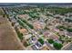 A captivating aerial view of a residential neighborhood with lush landscaping and neatly arranged homes; the subject house is marked at 4604 Barbados Loop, Clermont, FL 34711