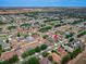 A sweeping aerial shot showcasing a well-planned community with varied homes and the subject property highlighted by a red arrow at 4604 Barbados Loop, Clermont, FL 34711