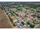 A captivating aerial view of a residential neighborhood with lush landscaping and neatly arranged homes; the subject house is marked at 4604 Barbados Loop, Clermont, FL 34711