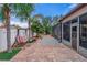 Brick paved backyard with a swing, screened-in patio, and privacy fence at 4604 Barbados Loop, Clermont, FL 34711