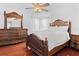 A bedroom with a large carved wood bed and wood floors at 4604 Barbados Loop, Clermont, FL 34711