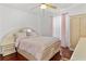 A cozy bedroom with a large bed, ceiling fan and wood floors at 4604 Barbados Loop, Clermont, FL 34711