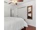 A bedroom with a closet, door, mirror, and wood floors at 4604 Barbados Loop, Clermont, FL 34711
