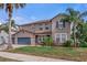 Charming two-story home with well-manicured lawn, mature palms, and a welcoming front porch at 4604 Barbados Loop, Clermont, FL 34711