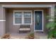 Cozy covered front porch featuring a decorative front door, bench, and potted plants at 4604 Barbados Loop, Clermont, FL 34711