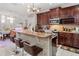 Charming kitchen with bar seating, dark wood cabinets, and stainless steel microwave at 4604 Barbados Loop, Clermont, FL 34711
