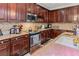 Kitchen with granite counters, a stainless range, and dark cabinets at 4604 Barbados Loop, Clermont, FL 34711