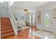 Inviting foyer and living room with wood floors, stairs, and an arched doorway at 4604 Barbados Loop, Clermont, FL 34711