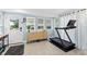 Bright exercise room with natural light, neutral walls and floors, plus exterior door and a sleek treadmill at 51 Silk Moss Ct, South Daytona, FL 32119