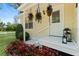 Inviting front porch with decorative hanging plants and colorful flower bed at 51 Silk Moss Ct, South Daytona, FL 32119